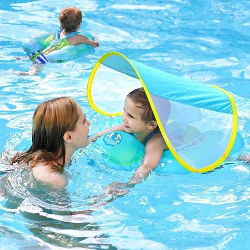 Niños pequeños con flotadores en una piscina, disfrutando del verano.